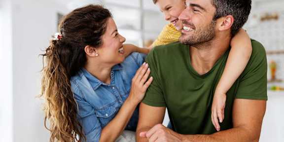A man and a woman are sitting closely together, sharing a joyful moment. at Infinity on the Landing Apartments, Euless 76040
