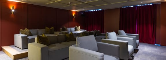 a room with couches and chairs and a red curtain