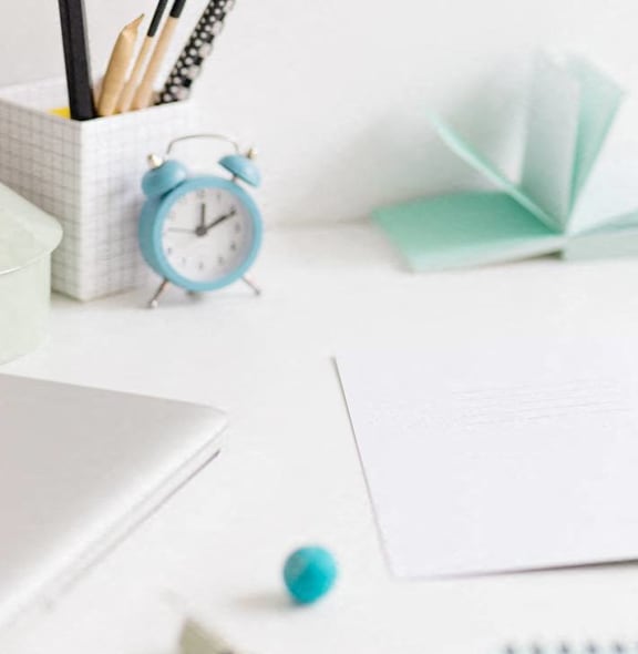 a desk with a notebook and a cup of coffee