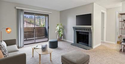 Model Living Room with Carpet, Fireplace and Patio Accessibility at Grammercy Apartments located in Renton, WA-HERO.