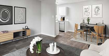 Model Living Room with Carpet and View of Dining Room with Wood-Style Flooring at The Archer Apartments in Sacramento, CA-HERO.