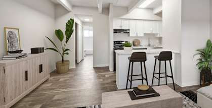 Model Living Room with Wood-Style Flooring and View of Kitchen at Esprit at Cherry Creek Apartments in Glendale, CO-HERO.