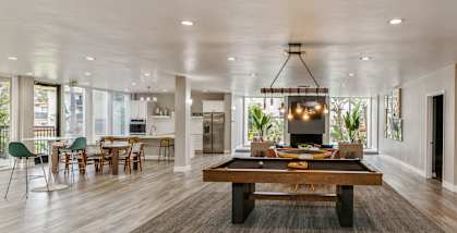 Community Clubhouse with Lounge Furniture and Game Tables at Crystal View Apartments located in Garden Grove, CA.