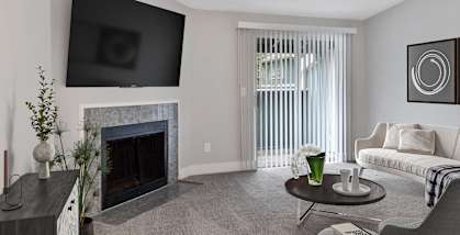 Model Living Room with Carpet and Patio Accessibility at Sunset 320 Apartments in Federal Way, WA-HERO.
