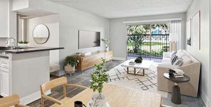 Model Dining Room with Wood-Style Flooring and View of Living Room with Patio Accessibility at Madison Park Apartments located in Anaheim, CA-HERO.