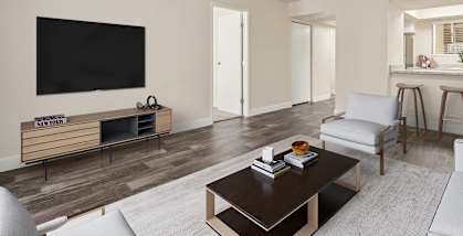 Model Living Room with Wood-Style Flooring and view of Kitchen at Butler Ridge Apartments located in Glendale, AZ-HERO.