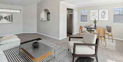 Model Living Room with Carpet and View of Kitchen/Dining Area at Hidden Creek Apartments located in Lewisville, TX-HERO.