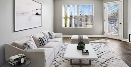 Model Living Room with Wood-Style Flooring and Patio Accessibility at Fox Valley Villages Apartments located in Aurora, IL-HERO.