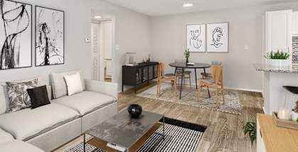 Model Living Room with Wood-Style Flooring and View of Kitchen/Dining Area at Seven Lakes at Carrollwood Apartments in Tampa, FL-HERO.