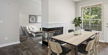 Model apartment dining room with a table and chairs and a fireplace