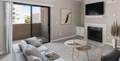 Model apartment living room with a couch and a table and a fireplace