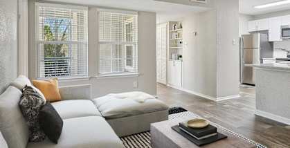 Model apartment living room and kitchen with a couch and a table