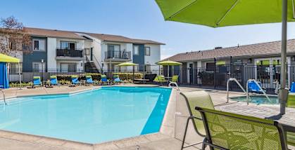 Community swimming pool with chairs and umbrellas