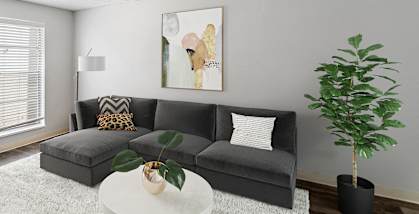 Model apartment living room with a gray couch and a white table