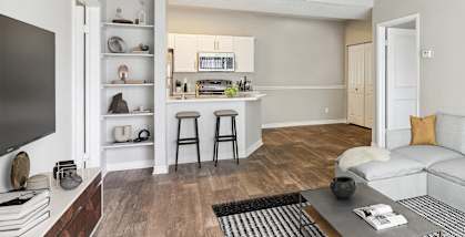 Model apartment living room and kitchen with a couch and a table