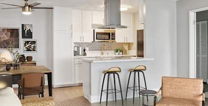 Model Kitchen with White Cabinets and Wood-Style Flooring at Cove La Mesa Apartments located in La Mesa, CA-HERO.