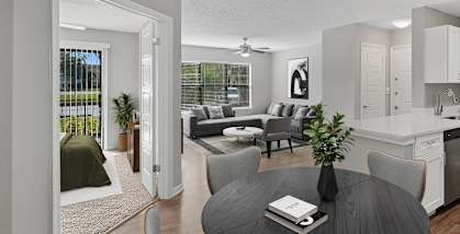 Model Dining Room with Wood-Style Flooring & View of Kitchen/Family Room at Fountains Lee Vista Apartments in Orlando, FL