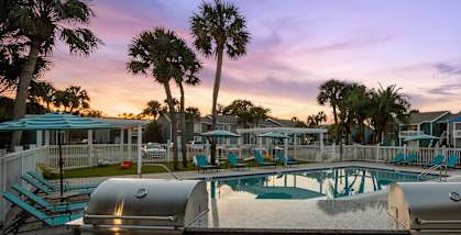 Outdoor BBQ Area with Furniture and Pool View at Park at 7200 Apartments in Jacksonville, FL-HERO.