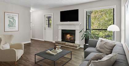 Model Living Room with Wood-Style Flooring and Fireplace at Lakeside Retreat Apartments located in Peachtree Corners, GA-HERO.
