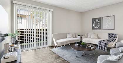 Model Living Room with Wood-Style Flooring and Patio Accessibility at Paramont Apartments in Duluth, GA-HERO.