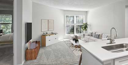Model Kitchen with White Cabinets and View of Living Room at Arbor Village Apartments located in Charlotte, NC-HERO.