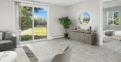 Model Living Room with Carpet and Patio Accessibility at Village at Marshfield Apartments located in Marshfield, MA-HERO.