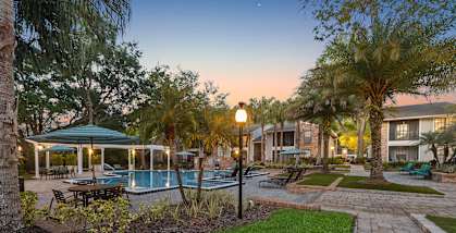 Community Swimming Pool with Pool Furniture at Grand Pavilion Apartments in Tampa, FL-HERO.