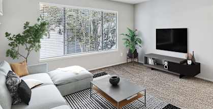 Model apartment living room with a couch and a television