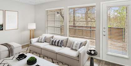 Model Living Room with Carpet and Patio Accessibility at Woodcreek Apartments located in Arlington, TX-HERO.