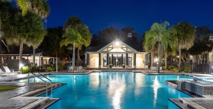 Community Swimming Pool with Pool Furniture at Caribbean Breeze Apartments in Tampa, FL-HERO.
