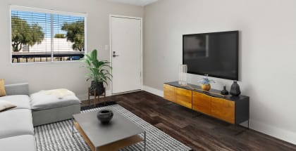 Model apartment living room with a white couch and a television