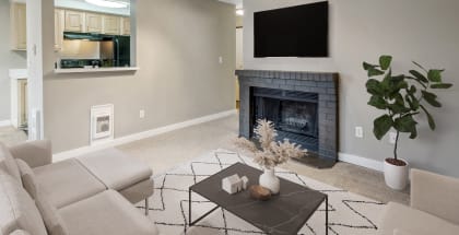 Model apartment living room with a fireplace and a couch