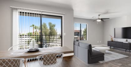 Model living room with a couch and a table and a tv at Harmony at Surprise, Surprise, AZ