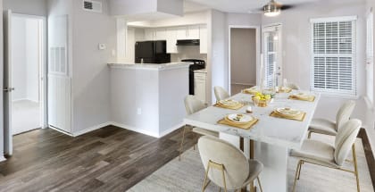 Model apartment dining room and kitchen with a white table and chairs