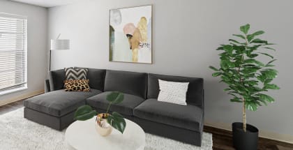 Model apartment living room with a gray couch and a white table