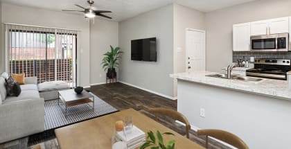 Model Dining Room with Wood-Style Flooring and View of Living Room at Dallas North Park Apartments in Dallas, TX-HERO.