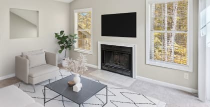 Model Living Room with Carpet and Fireplace at Woodland Estates Apartments in Charlotte, NC-HERO.