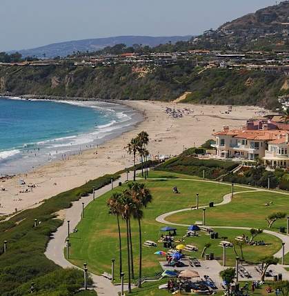 A beach with people on it and a building in the distance at The Villas at Monarch Beach, Dana Point, CA, 92629