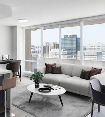 A modern kitchen with a bar area and a living room area with a couch.