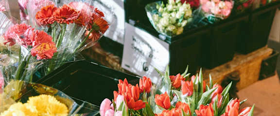 a bunch of flowers in plastic containers on a table