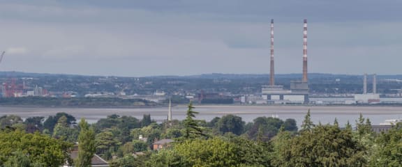a view of a city with two chimneys and a river