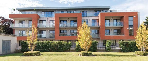 a large apartment building with a yard in front of it