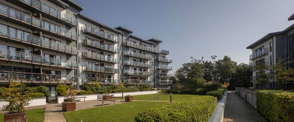 a view of an apartment building with a park in front of it