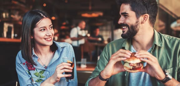 A man and a woman are enjoying a meal together in a restaurant.
