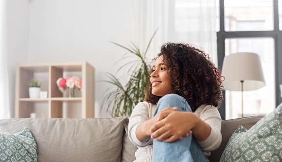 A man and woman are laughing together on a couch.