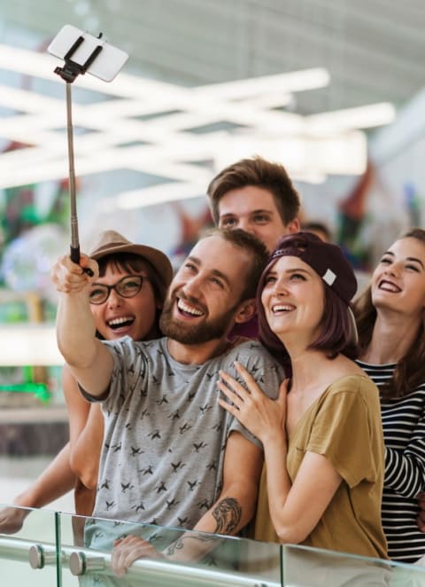 a group of people looking up at a surveillance camera in a mall