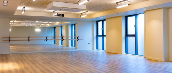a large room with a wooden floor and blue windows