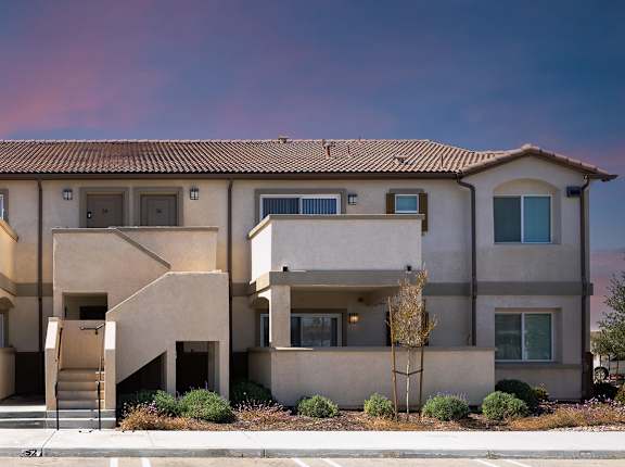 A large apartment building with a parking lot in front.