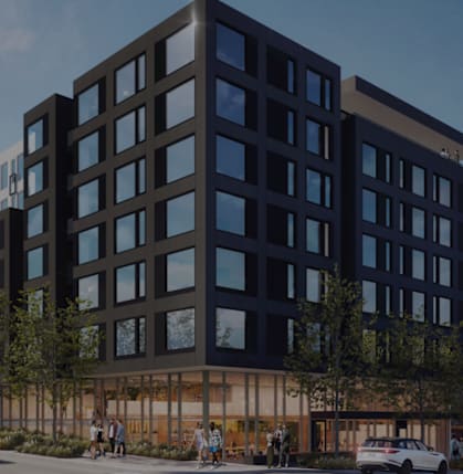 A modern multi-story building with a glass facade is depicted in the image.