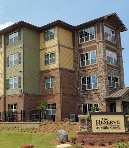 an apartment building with a sign in front of it